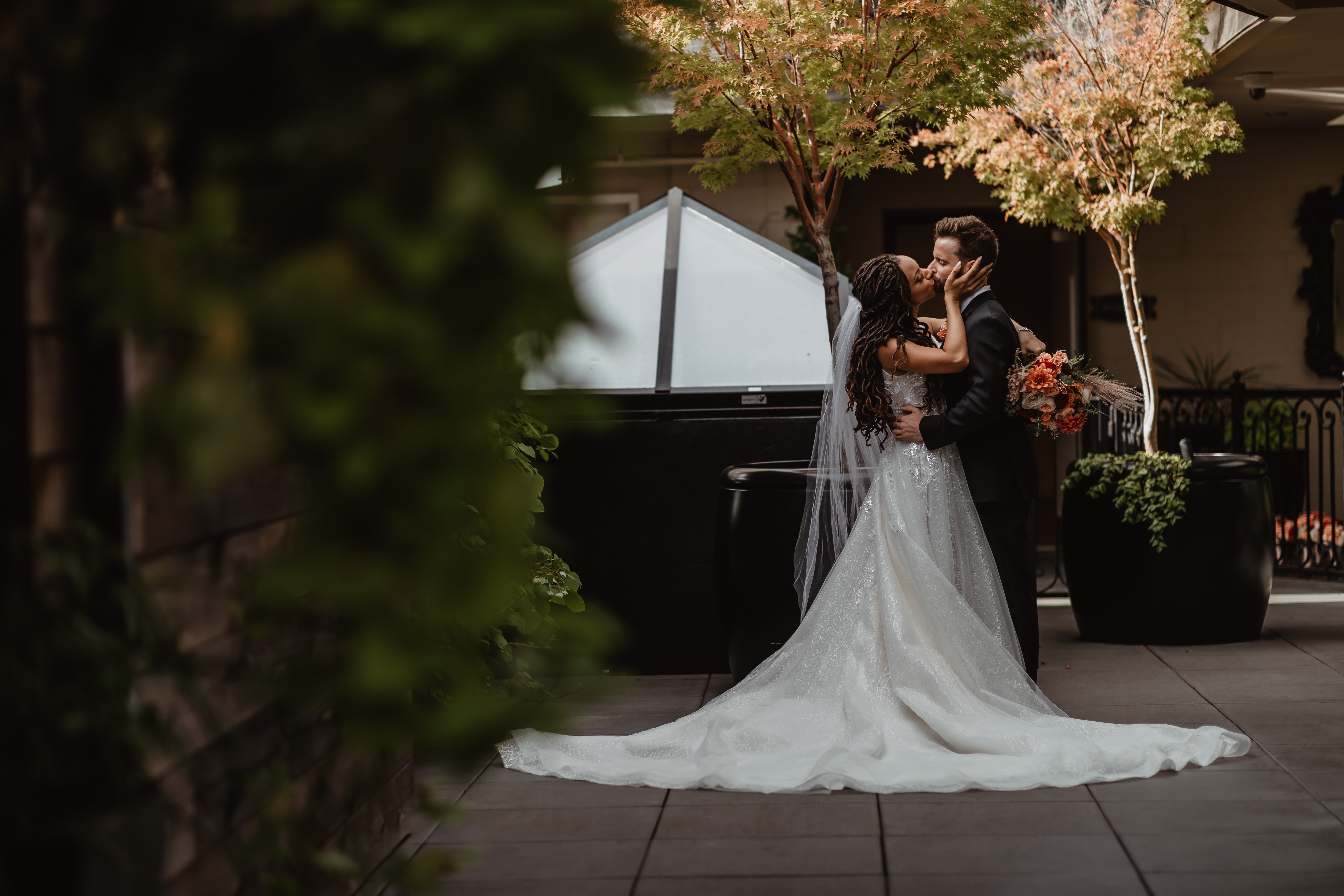 Bride and groom embracing during couple's portraits on top of the Olympic Rooftop Pavilion before their wedding.