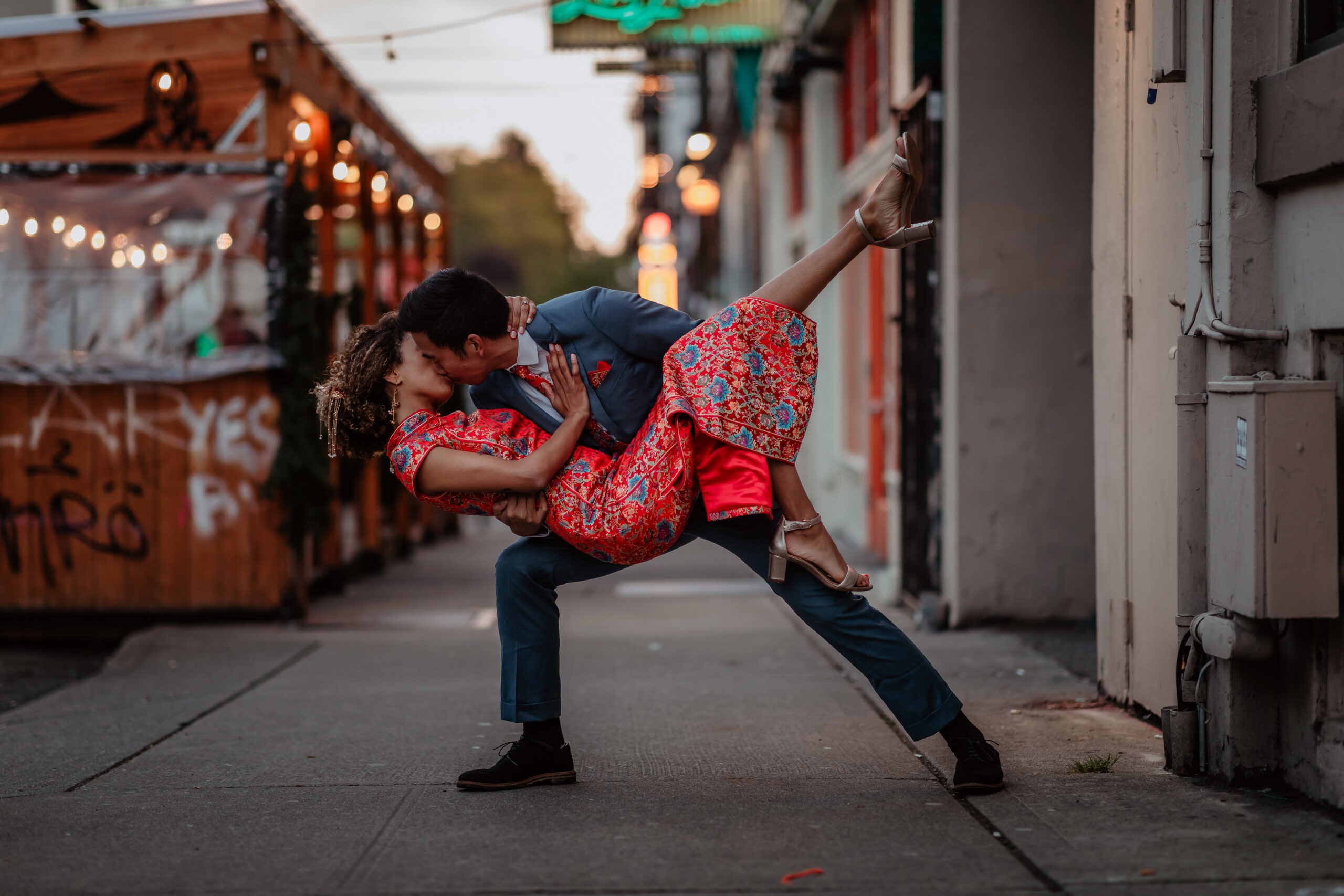 Man dipping woman in cheongsam while they kiss in Capitol Hill