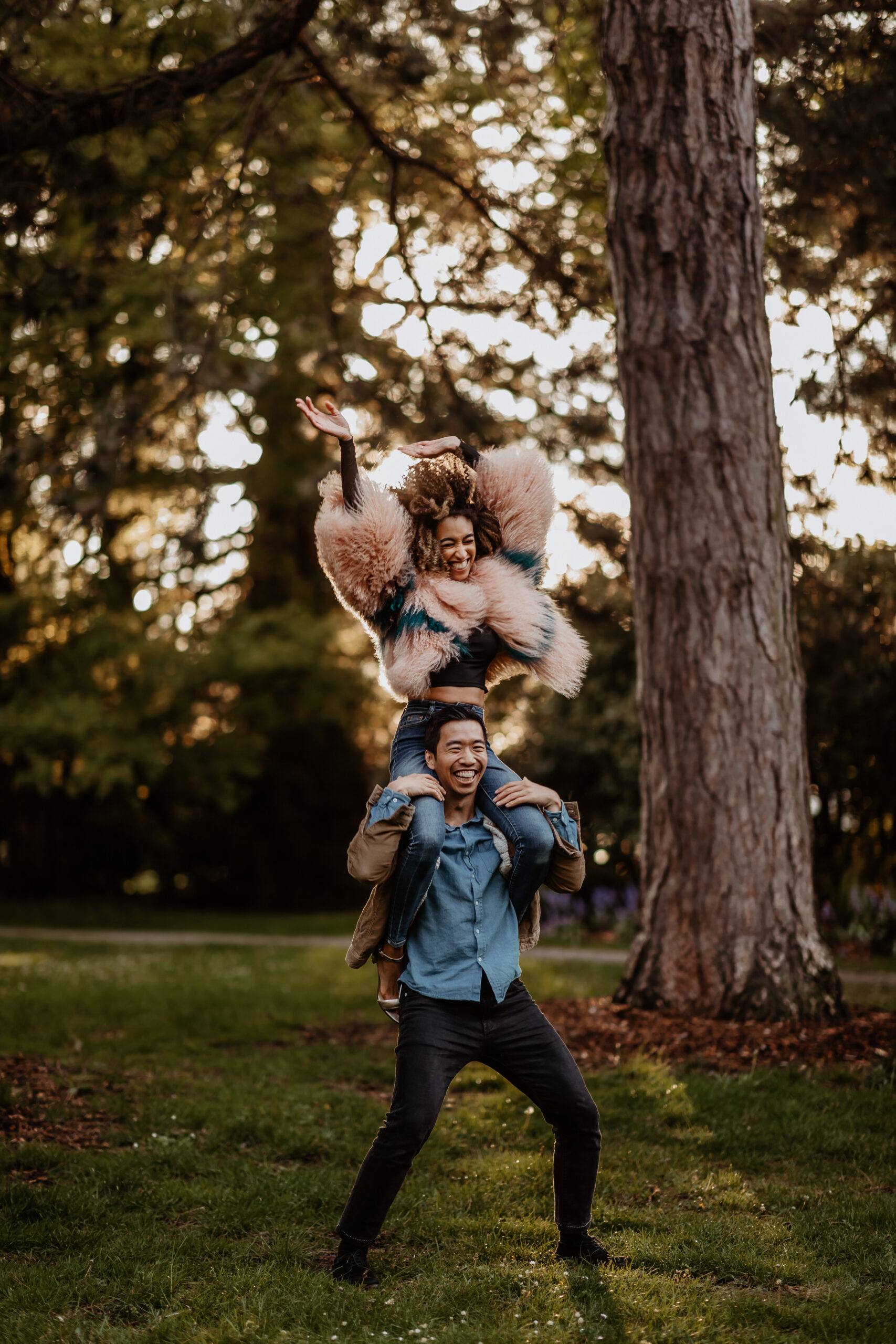 Woman sitting on man's shoulders and dancing during spring engagement session