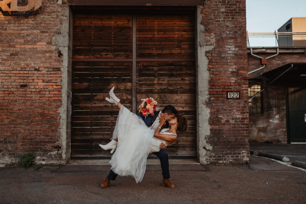 bride being dipped in front of brick wall seattle